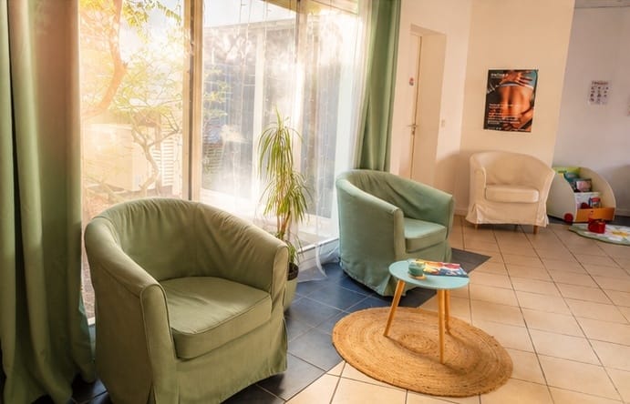 Espace d’accueil lumineux avec des fauteuils verts